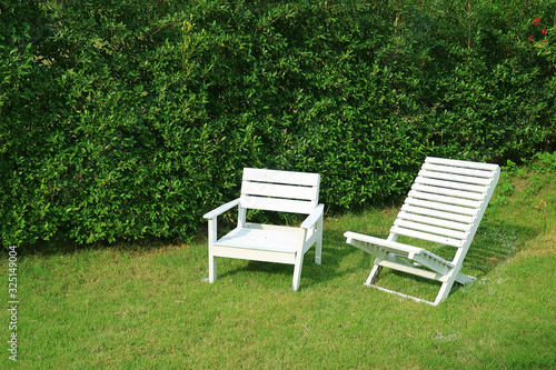 Two empty white colored wooden chairs in the sunshine garden © jobi_pro