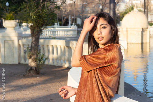 Portrait of pretty caucasian young woman posing, wearing longsleave shirt and jeans with dark hair, winter clothing.