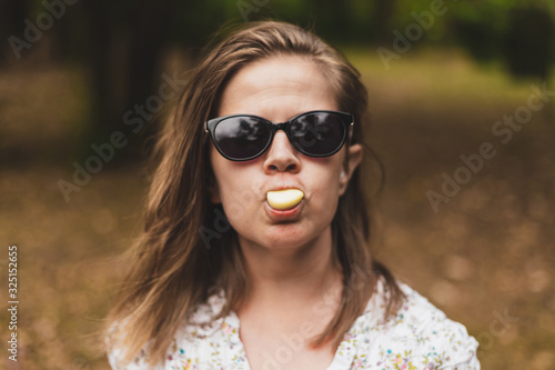 Funny woman holding garlic between her lips © madrolly