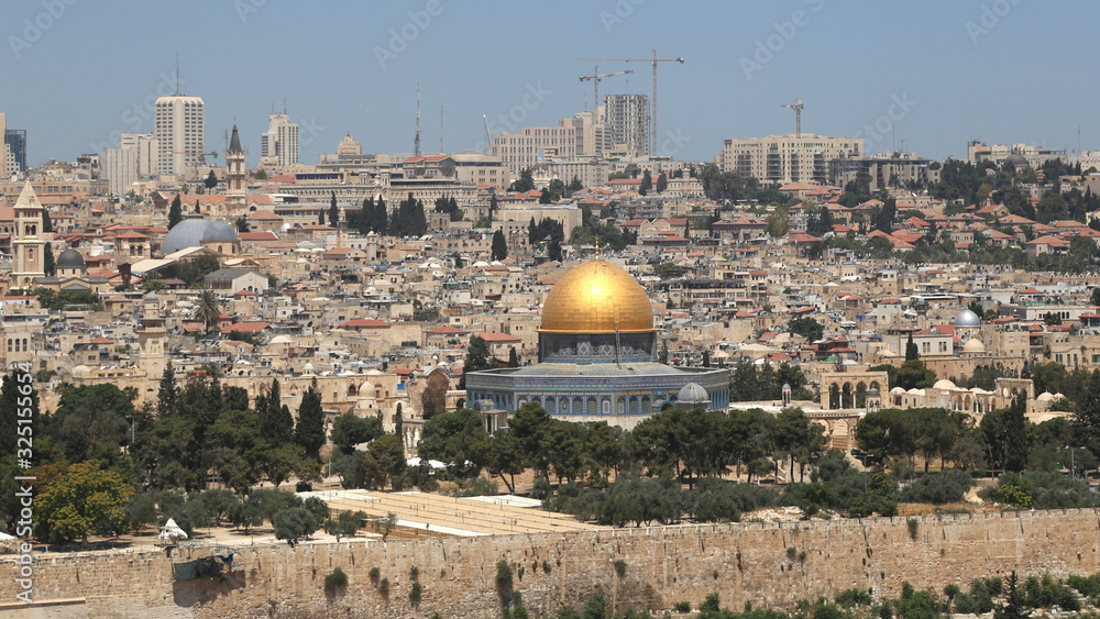 Dome of the Rock in the Jerusalem old city with skyscrapers of the modern Jerusalem in the background.