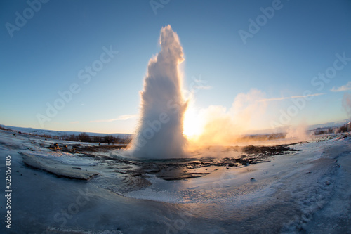 Strokkur Geysir geyser on the south west Iceland. Famous tourist attraction Geysir on route 35 in sunrise. High eruption of boiling water at geothermal area Haukadalur. Water fountain in winter.