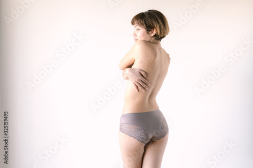 Young caucasian coman in underwear on white background