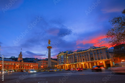 Tbilisi, Georgia, 19 December 2019 -urban landscape Freedom Square with blurred cars on a long shutter speed and a beautiful pink sunset sky