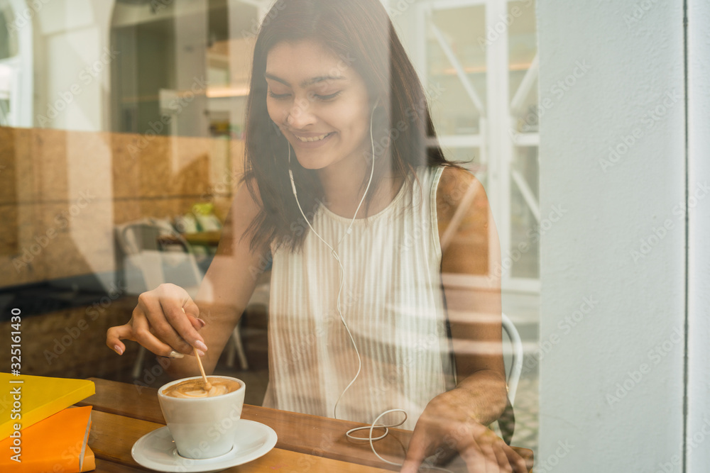 Young woman drinking a cup of coffee at coffee shop. Young woman drinking a cup of coffee at coffee shop.