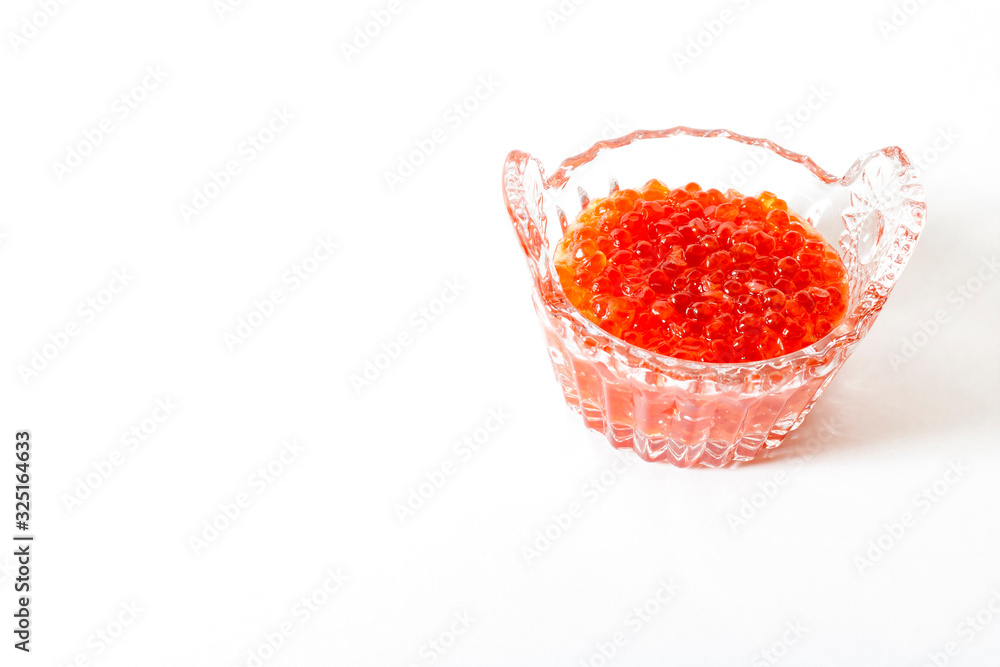 Red salmon caviar in a glass caviar bowl on a white background. Delicacy Red salmon caviar in a glass caviar bowl on a white background. Delicacy