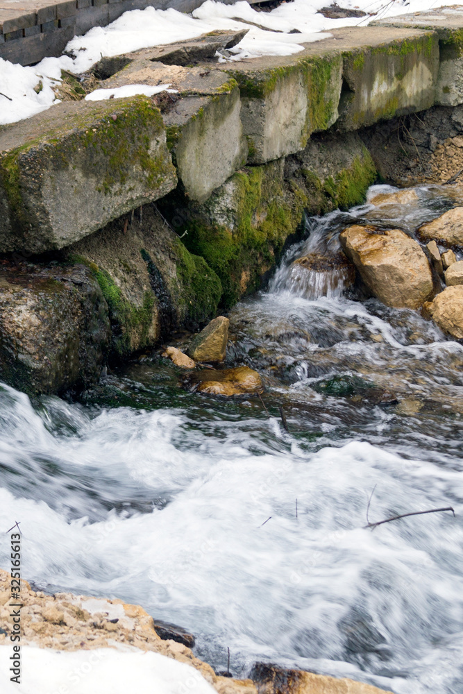 creek runs over stones in early spring creek runs over stones in early spring
