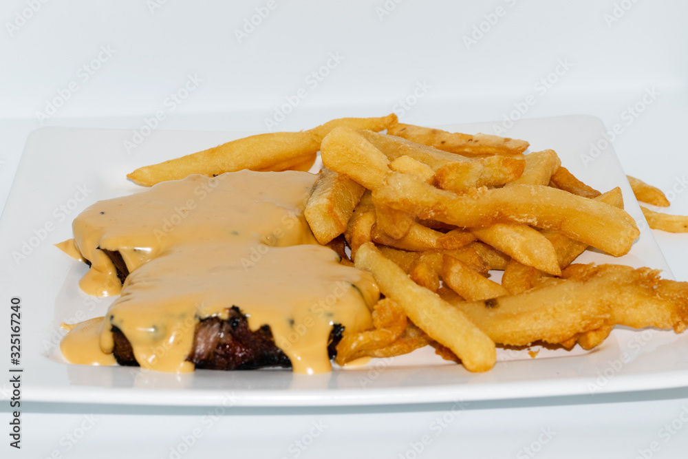 Argentinian food. Milanesa with bacon and cheese with french fries Argentinian food. Milanesa with bacon and cheese with french fries