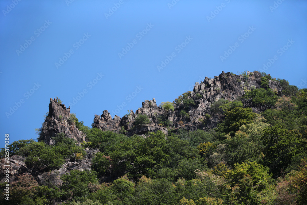 Gebirgszug Wand aus Felsen und Steinen mit Bäumen im Vordergrund
