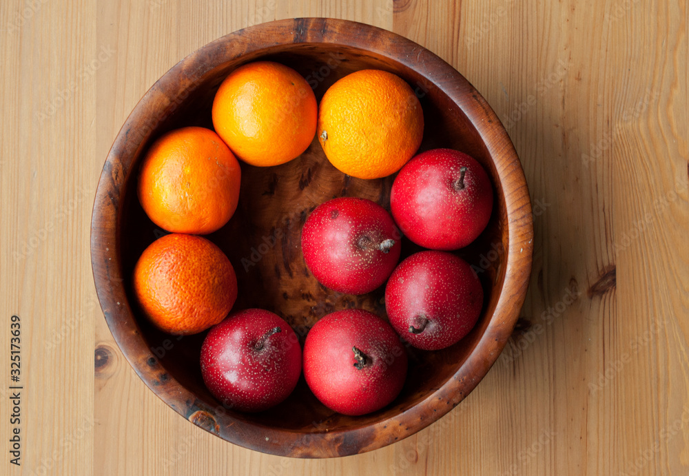 Overhead shot of beautiful wooden bowl of autum and winter fruits - blood oranges and nashi pears (asian pears, Japanese pears) on a wooden kitchen table. Overhead shot of beautiful wooden bowl of autum and winter fruits - blood oranges and nashi pears (asian pears, Japanese pears) on a wooden kitchen table.