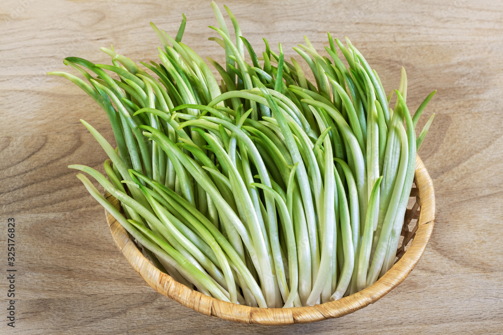 wild garlic sprouts in a wicker basket on a wooden background closeup wild garlic sprouts in a wicker basket on a wooden background closeup