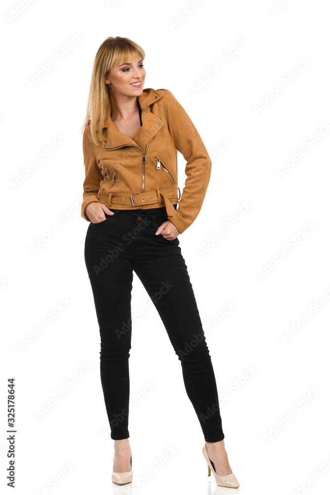 Young Woman In Brown Suede Jacket Is Standing With Hands In Pockets And Looking Away Young Woman In Brown Suede Jacket Is Standing With Hands In Pockets And Looking Away