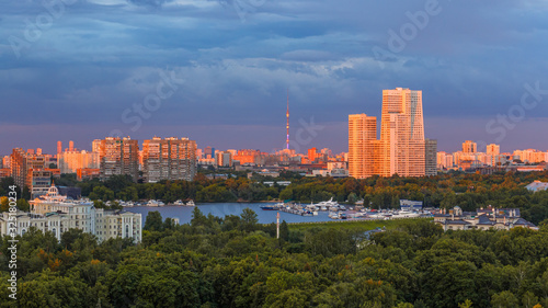 Moscow city skyline at sunset , panoramic view. Amazing colourful scenery of the park, river with luxury yachts, sunlit buildings. 
