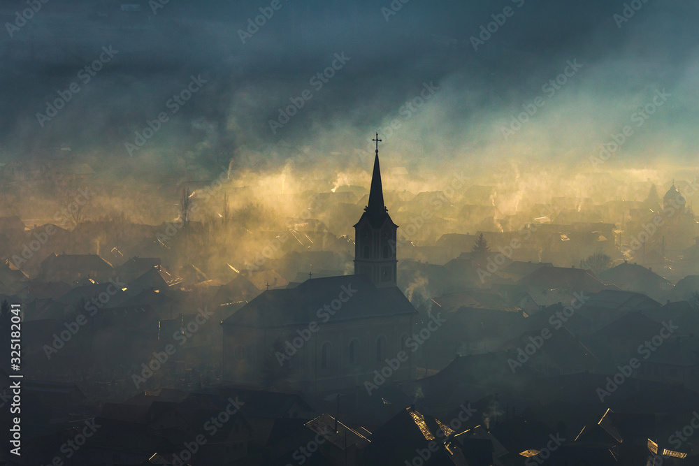 Fototapeta premium Church silhouette misty village landscape seen from above