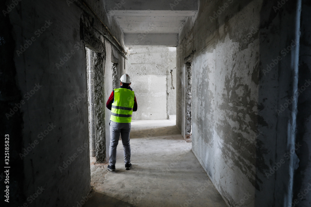 Worker in an unfinished building on a hospital construction site.