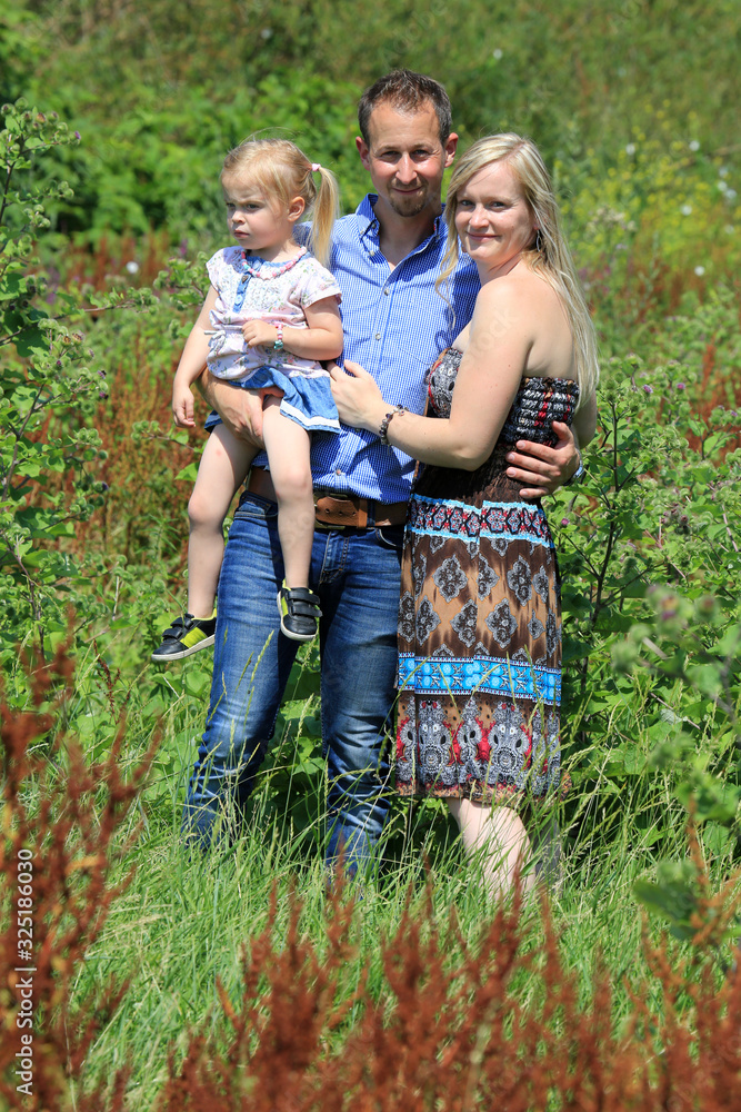 Fototapeta premium Glückliche, hübsche, junge Familie in der Natur