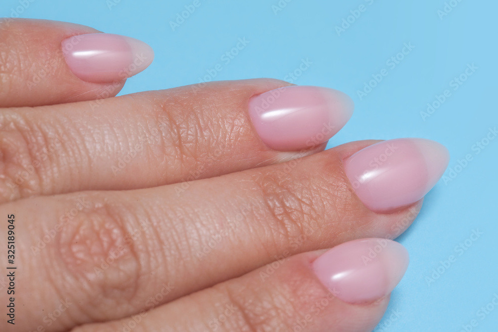 Women's hands with perfect Nude manicure. Nail Polish is a natural pale pink shade. Women's hands with perfect Nude manicure. Nail Polish is a natural pale pink shade.
