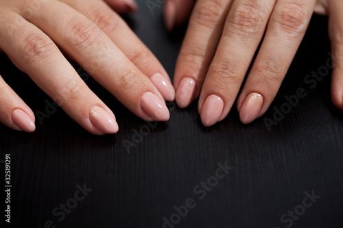 Women s hands with perfect Nude manicure. Nail Polish is a natural pale pink shade.
