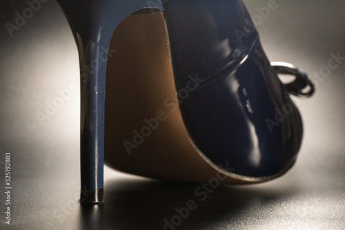 female high-heeled shoes of blue and glossy on a black background