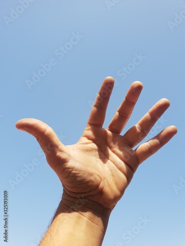 hand on blue sky background