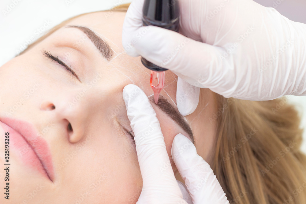 Make-Up. Beautician Hands Doing Eyebrow Tattoo On Woman Face.Permanent Brow Makeup In Beauty Salon. Closeup Of Specialist Doing Eyebrow Tattooing For Female. Cosmetology Treatment.