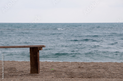 Un banco de madera en la arena mirando el horizonte