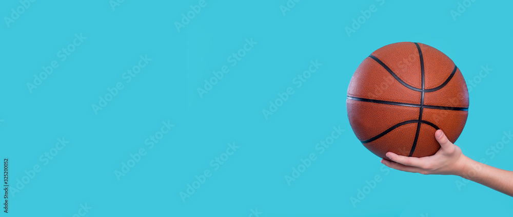Sportsman hand who holding basketball against blue background