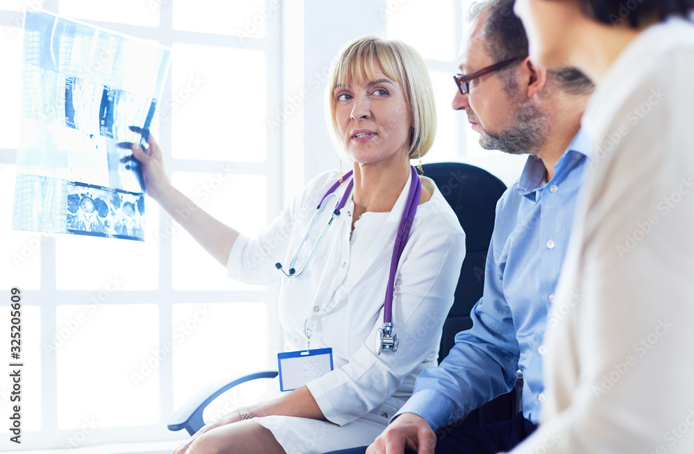 Doctor woman explaining x-ray results to patient Doctor woman explaining x-ray results to patient