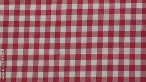 While the wooden table is covered by the red-white checkered tablecloth, the top view. Stock Video