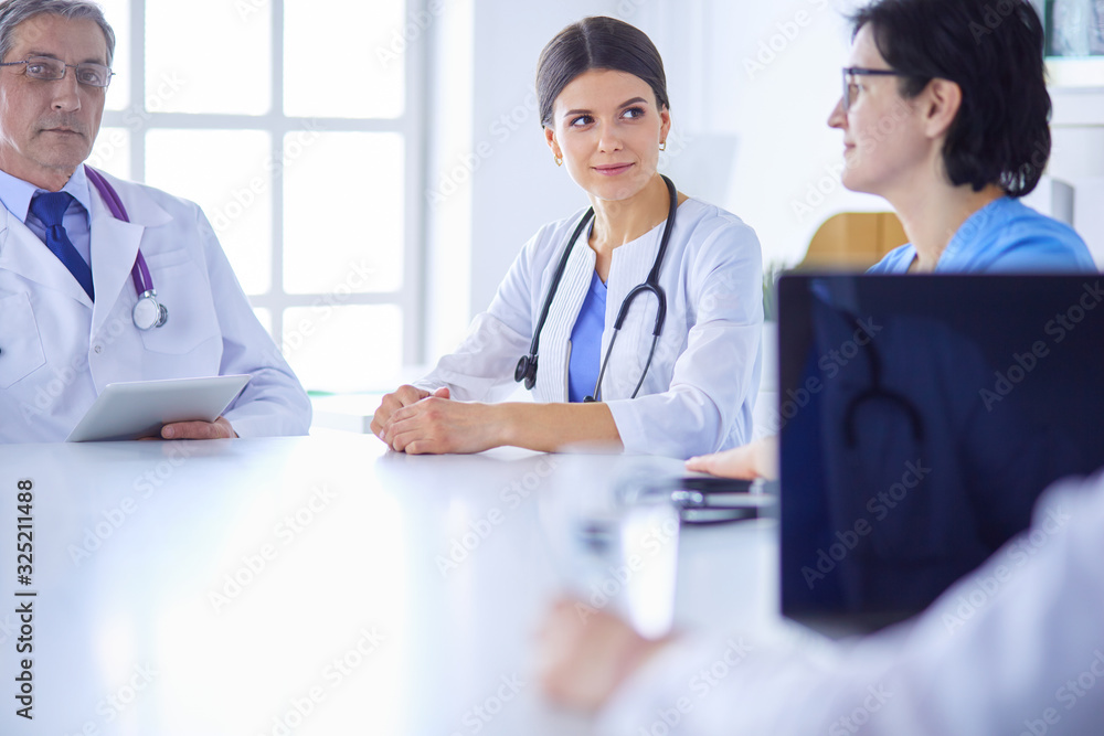 Serious medical team discussing patient's case in a bright office Serious medical team discussing patient's case in a bright office