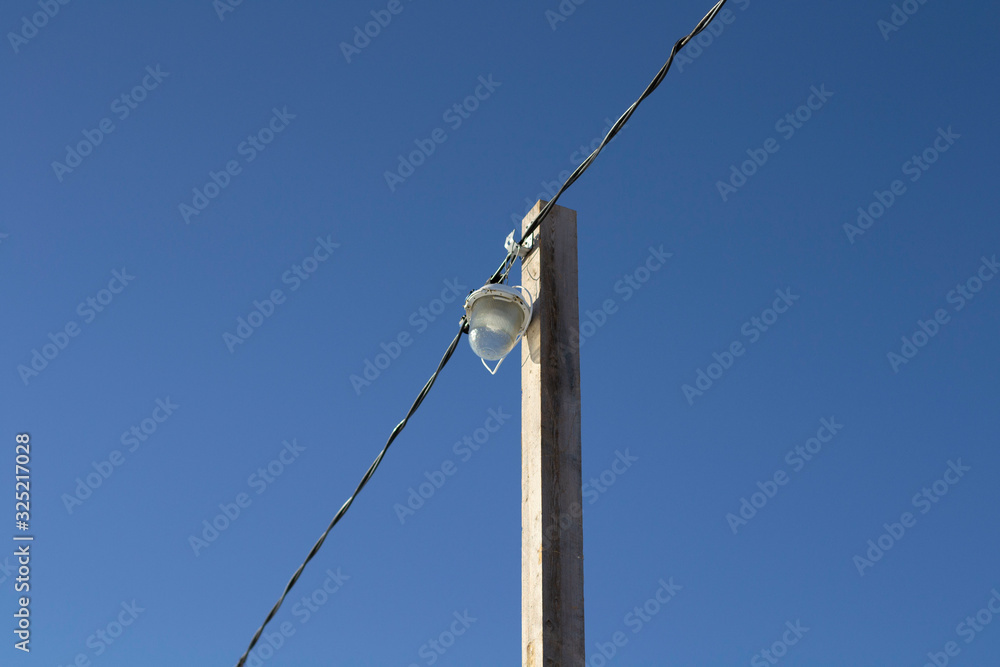 a lantern at a pedestrian crossing over a frozen river. a lantern at a pedestrian crossing over a frozen river.