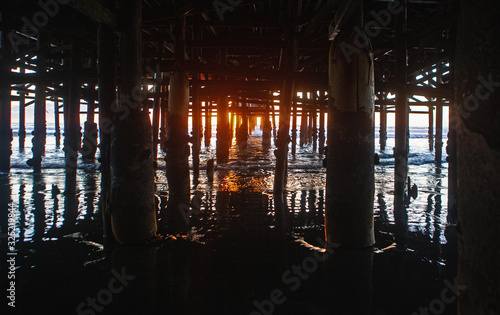 under the pier at sunset