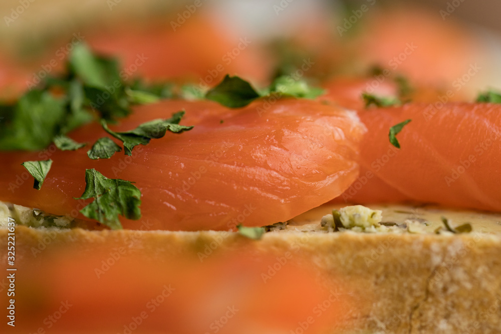 Close-up of trout lying on a slice of bread decorated with chopped parsley Close-up of trout lying on a slice of bread decorated with chopped parsley