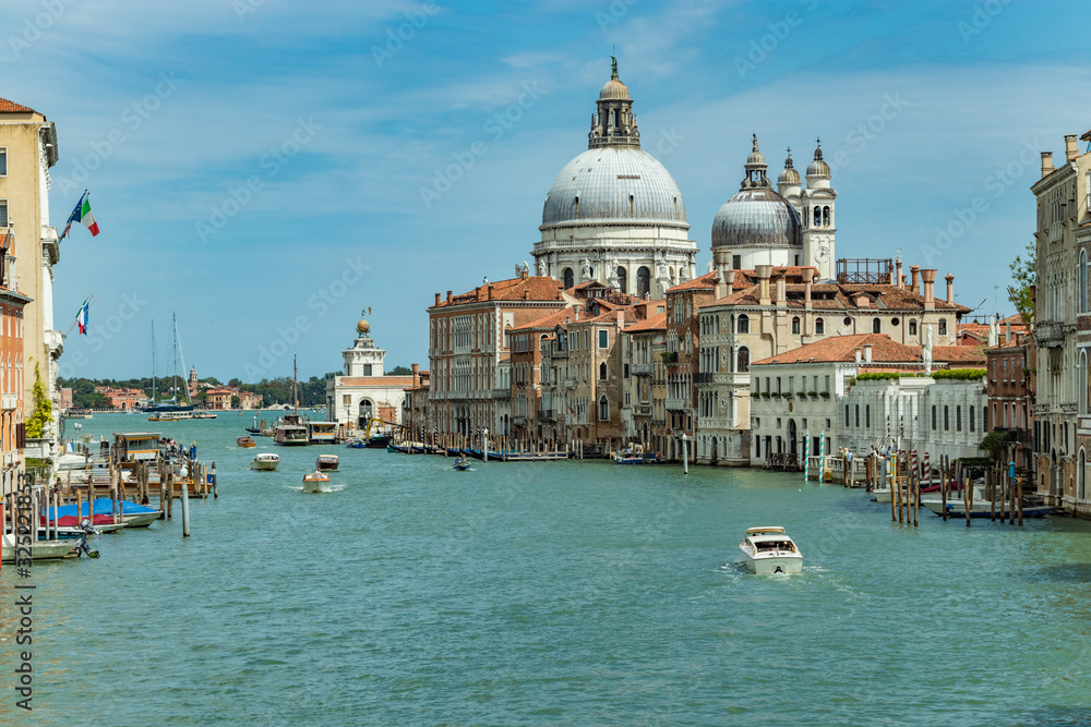 VENICE, ITALY - August 02, 2019: Grand Canal with Basilica di Santa Maria della Salute in Venice, Italy. View of Venice Grand Canal in sunny day. Architecture and landmarks of Venice