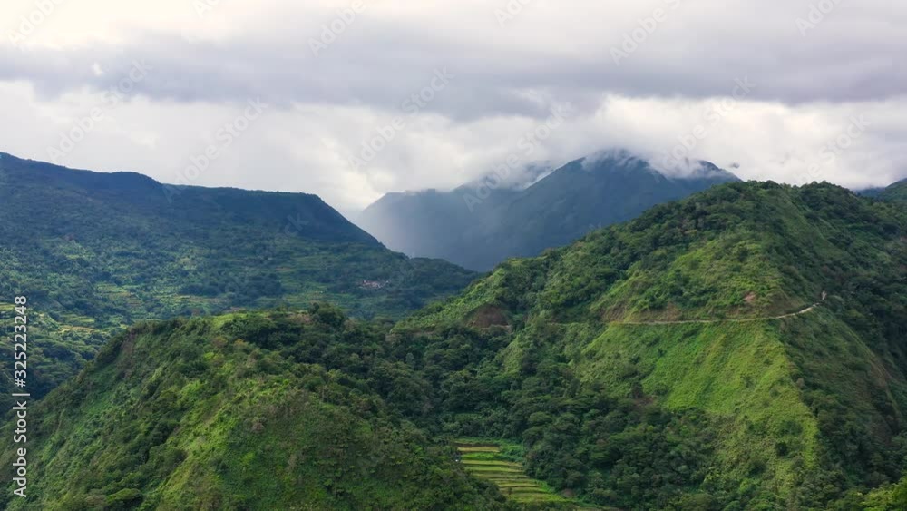 Cordillera on Luzon Island, Philippines, aerial view. Clouds cover the tops of the mountains. Mountain landscape, evergreen forest with tropical trees. Cordillera on Luzon Island, Philippines, aerial view. Clouds cover the tops of the mountains. Mountain landscape, evergreen forest with tropical trees.