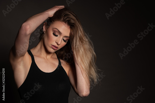 Beauty portrait of a gorgeous young woman over dark background