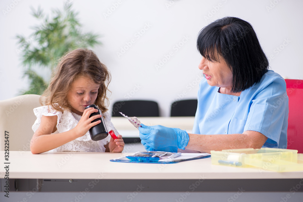 Little girl visiting old female doctor Little girl visiting old female doctor