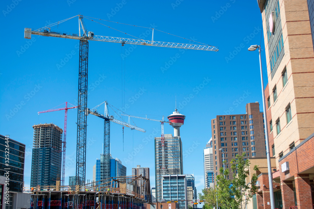 Modern building under construction in downtown with tower in background