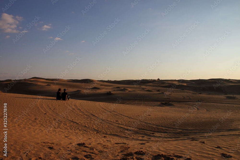 Romantic couple waching the desert sunset Romantic couple waching the desert sunset