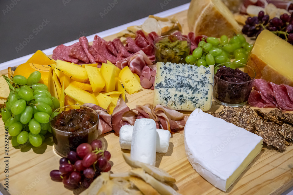cheese and cold meat board with grapes and bread