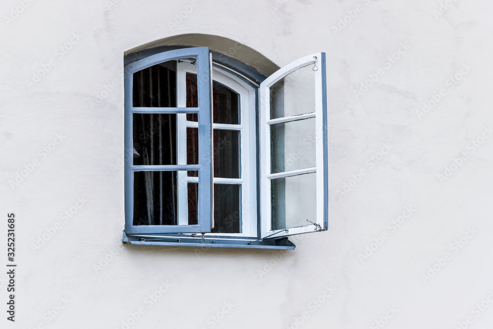 mediterranean building with blue window on white wall 