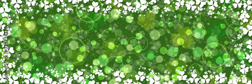 St.Patrick's Day green vector background with clover leaves and light effects 