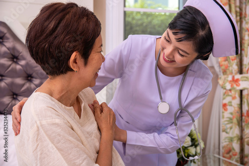 Young nurse take care senior woman on a bed, A nurse checking sernior  woman, Senior woman happniess and smiling with nurse, Health care concept photo