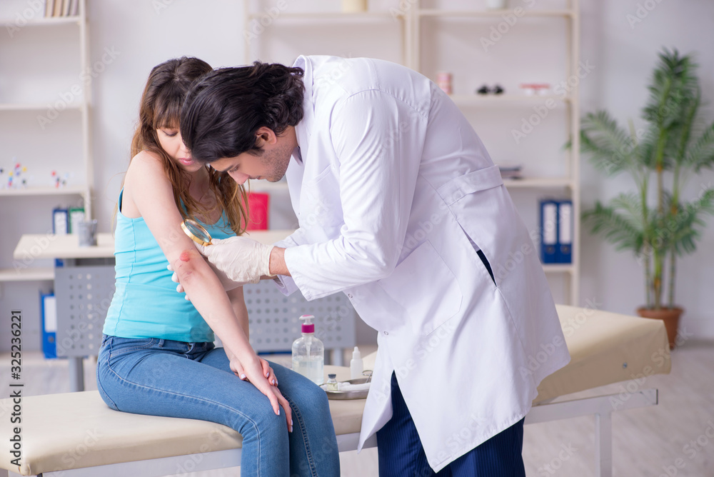 Young arm injured woman visiting young doctor traumatologist Young arm injured woman visiting young doctor traumatologist