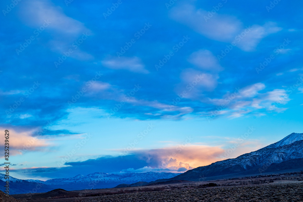 dawn sky clouds over snowy mountains