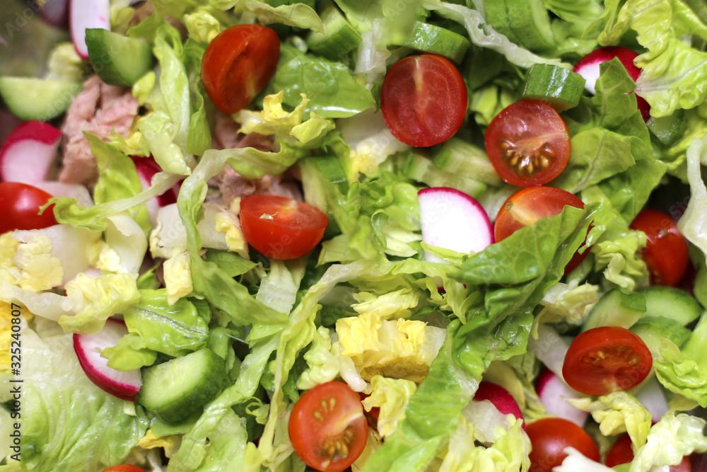 Fresh green salad with tomatoes, cucumbers, radishes and tuna. Mediterranean food. Healthy eating. Close-up vegetable salad Fresh green salad with tomatoes, cucumbers, radishes and tuna. Mediterranean food. Healthy eating. Close-up vegetable salad