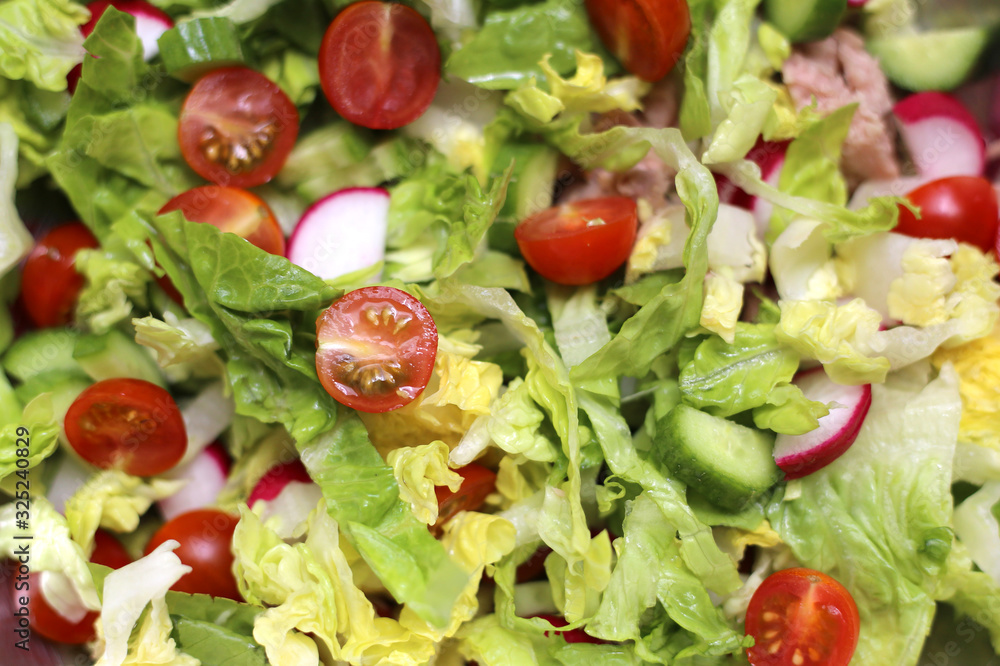 Fresh green salad with tomatoes, cucumbers, radishes and tuna. Mediterranean food. Healthy eating. Close-up vegetable salad Fresh green salad with tomatoes, cucumbers, radishes and tuna. Mediterranean food. Healthy eating. Close-up vegetable salad