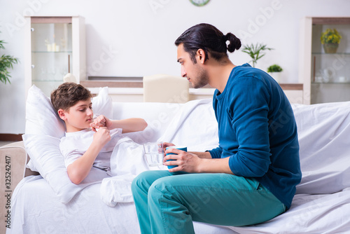 Young father caring for sick son © Elnur
