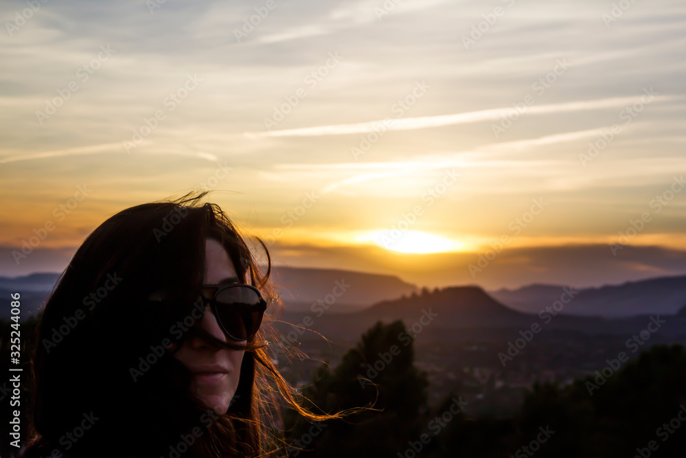 Woman with her hair blowing as the sun is setting Woman with her hair blowing as the sun is setting