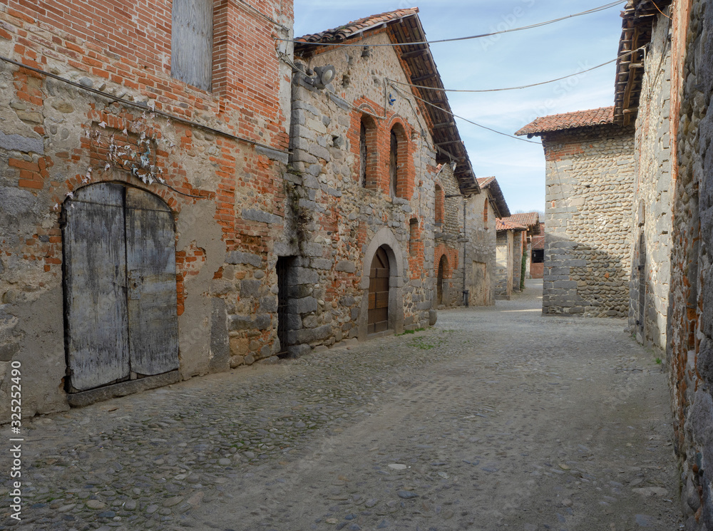 Ricetto di Candelo, brick buildings along the cobbled streets of the fortified medieval village. Piedmont - Italy