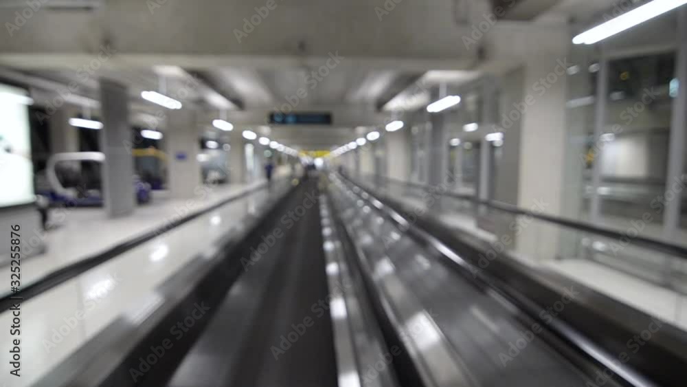 Out of focusing/blurred inside the airport while on flatted escalator while moving with passenger walking on it. Technology Transportation concept. Inside airport departure terminal building. Out of focusing/blurred inside the airport while on flatted escalator while moving with passenger walking on it. Technology Transportation concept. Inside airport departure terminal building.